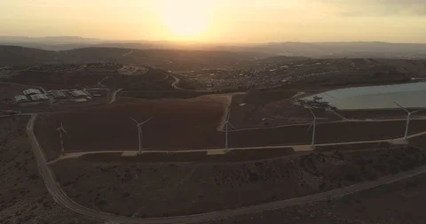 Flying towards the sunset above the wind turbines 4K Stock Footage 103793043