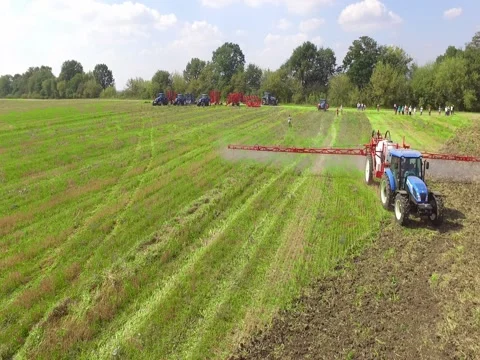 Flying Towards Tractor With Sprayer on Green Field Stock Footage 73718364