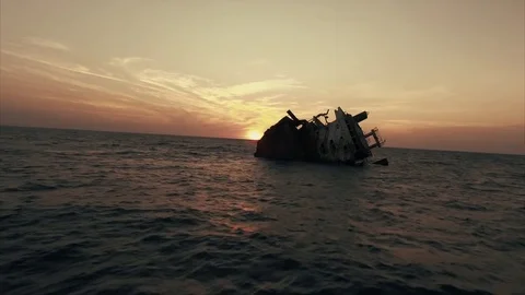 Flying towards wrecked ship in the ocean in the sunset Stock Footage 72160197