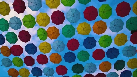 Flying Umbrellas. Multi colored Parasol Soar in the Sky. Umbrellas Suspended Stock Footage 97378621