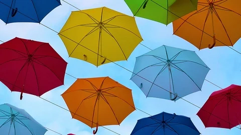 Flying Umbrellas. Multi colored Parasol Soar in the Sky. Umbrellas Suspended Stock Footage 97379130