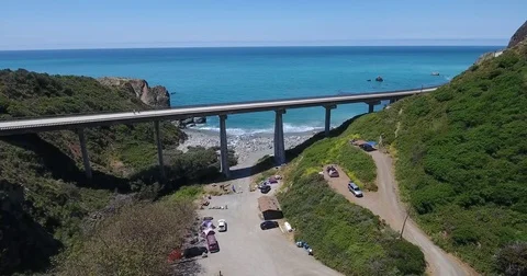 Flying under bridge by the coast of Big Sur, California Stock Footage 76334021