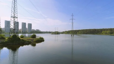 Flying under electricity pylons over river, lake, pond Stock Footage 109072645