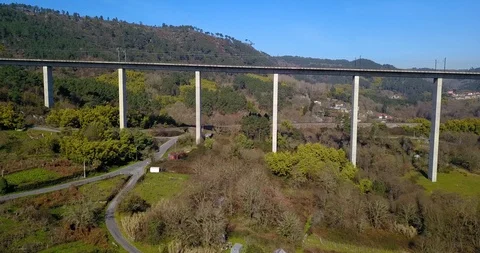 FLYING UNDER THE TRAIN BRIDGE IN A GREEN VALLEY Stock Footage 103266042