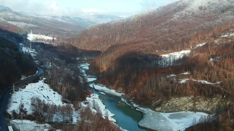 Flying upstream a river valley and along a road in Ciucas mountains, Romania Stock Footage 103317101