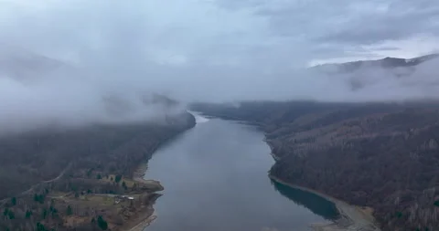 Flying upward on top of the clouds and fog reviewing beautiful mountain scenery Stock Footage 174453475