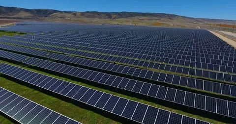 Flying view over solar panel farms toward fields of flowers Stock Footage 104812381