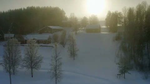 Flying up from village to thick winter clouds and large winter Sun. Sunset Stock Footage 124611944