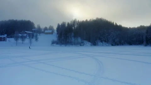 Flying up from village to thick winter clouds and large winter Sun. Sunset Stock Footage 124652564