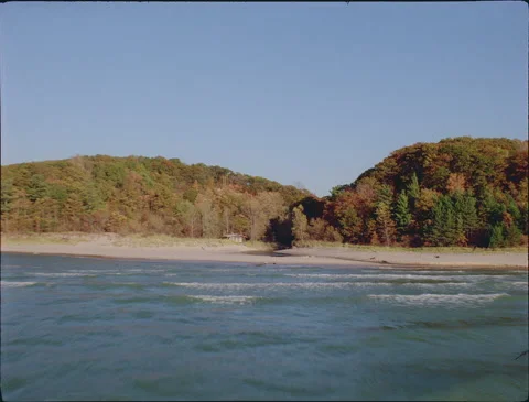 Flying at wave tops over river mouth and cabin 1990s 35mm film Stock Footage 136385086