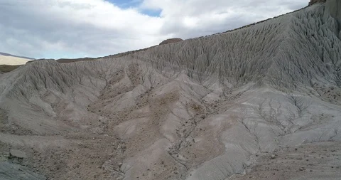 Flying on white desertic mountain slope, natural linear patterns from erosion 스톡 동영상 103493544