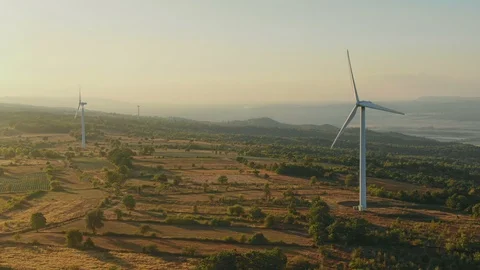Flying to Wind turbines generating renewable, sustainable energy in mountains 库存影片 115989814