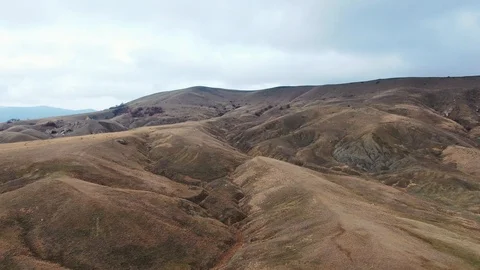 Flying on a wing over a hillside with dry grass in autumn Stock Footage 105671039
