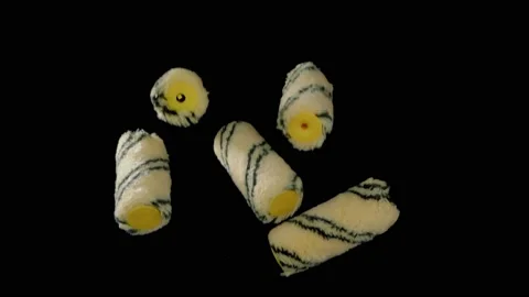 Flying yellow paint rollers on a black background. Repair accessories. Super Stock Footage 149242382