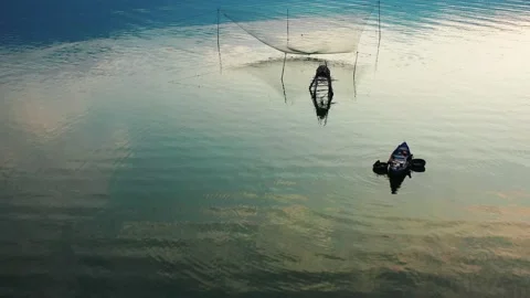 FlyingOverFishingNetInLangcoLakeAtSunset Stock Footage 147869622