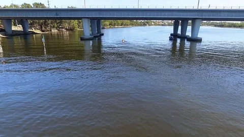 Flyover canoe kayak on river fly under bridge aerial footage Stock Footage 100388917