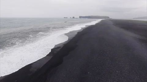 Flyover Coast Viewing Distant Island At Black Sand Beach in Vík í Mýrdal Iceland Stock Footage 64072140