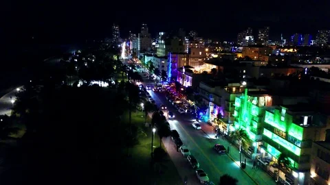 Flyover colorful and lit up Ocean Drive at night in Miami. 4K Stock Footage 127381663
