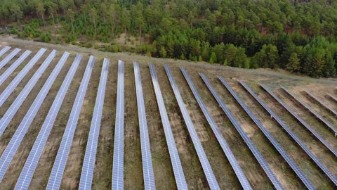 Flyover dolly out of solar panel field in forest Stock Footage 138756806