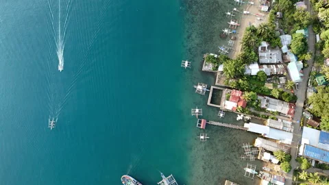 A flyover drone shot captures Liminangcong coastal village with anchored boats, Stock Footage 336692899