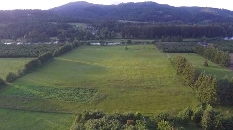 Flyover Field and Trees Towards Small River Stock Footage 76142247