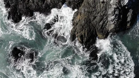 Flyover ocean waves breaking onto rocks Stock Footage 98394735