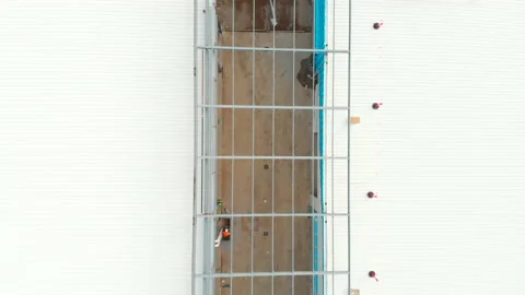Flyover over construction site peering through roof foundation Stock Footage 135205525