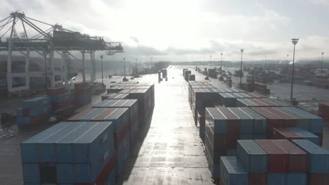 Flyover a Shipping Yard with Rows of Stacked Shipping Containers Stock Footage 208762924