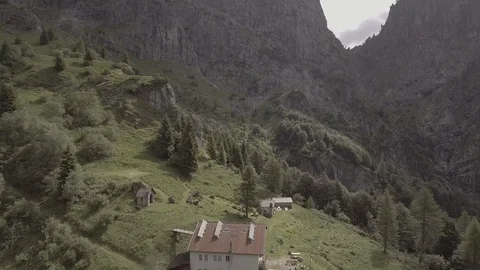 Flyover shot of one of the Dolomite Mountains in Italy with a mountain hut Stock Footage