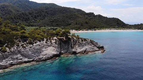 Flyover a small cliff at sea with view to a beach with turqoise water Stock Footage 91947731
