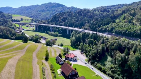 Flyover surrounding fields and forests and the surrounding mountains. Stock Footage 288074054