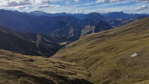 Flyover unspoiled rugged grassy mountain slopes going to the horizon 動画素材 333029783