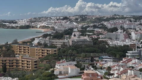 Flyover of whitewashed Albufeira and Praia dos Pescadores beach Видео 346651774