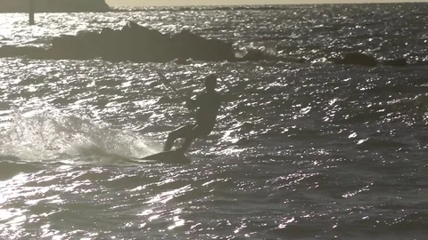 Flysurfer performing acrobatic stunt while wakeboarding in sea Stock Footage 77805464