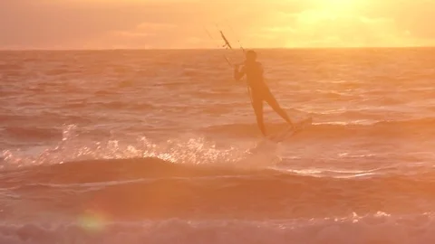 Flysurfer performing acrobatic stunt while wakeboarding in sea Stock Footage 77805512
