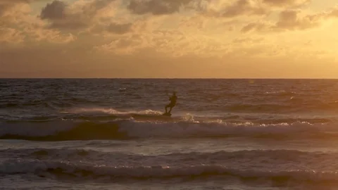 Flysurfer performing acrobatic stunt while wakeboarding in sea Stock Footage 77805566