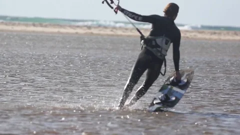 Flysurfer walking with wakeboard in sea Stock Footage
