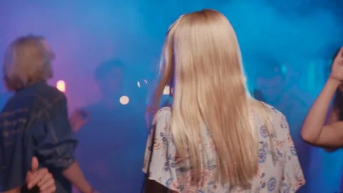 Flythrough shot of cheerful youth dancing in the nightclub. Focus on sexy Stock Footage 115367153