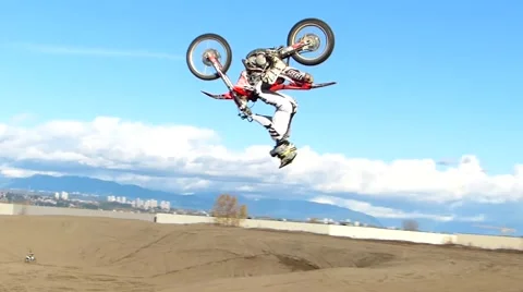 FMX rider backflips across a dune Stock Footage 56949514