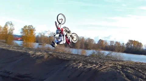 FMX rider backflips onto a sand dune Stock Footage 56967699