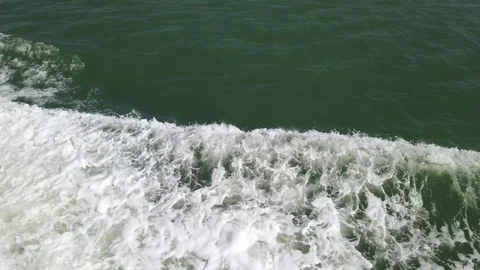 Foam and waves made by the bow of a boat sailing in a blue sea in summer Stock Footage 112242177