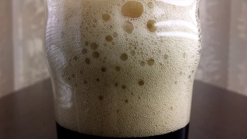 Foam bubbles and pours beer Stock Footage 71800757