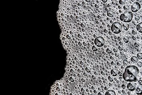Foam with bubbles pattern on dark water surface after heavy rain Stock Photos