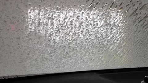 Foam flowing down on windshield interior view of automatic car wash Stock Footage 326438585