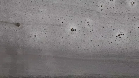 Foam flowing on grey surface with bubbles Видео 310409112