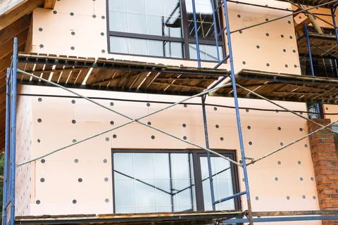 Foam insulation panels on external wall, scaffolding setup, mounting board,.. Fotos de archivo