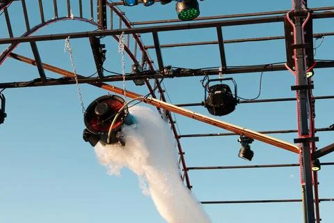Foam machine spraying soap bubbles from a metal stage truss structure Stock Photos