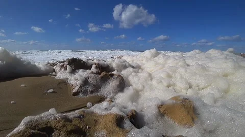 Foam of ocean waves by the shore flying Stock Footage 183989291