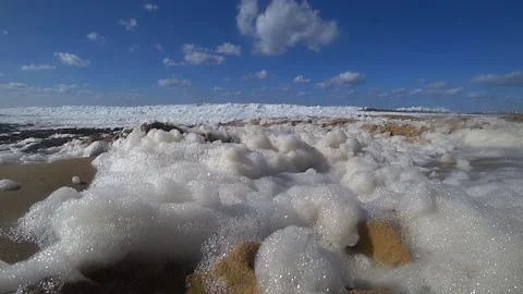 Foam of ocean waves by the shore flying Stock Footage 185865651
