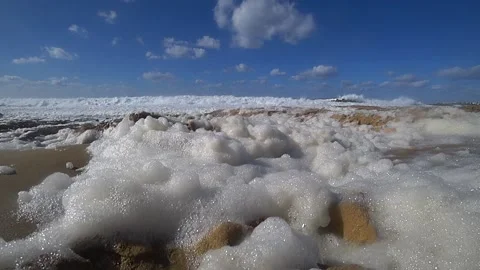 Foam of ocean waves by the shore flying Stock Footage 186493422